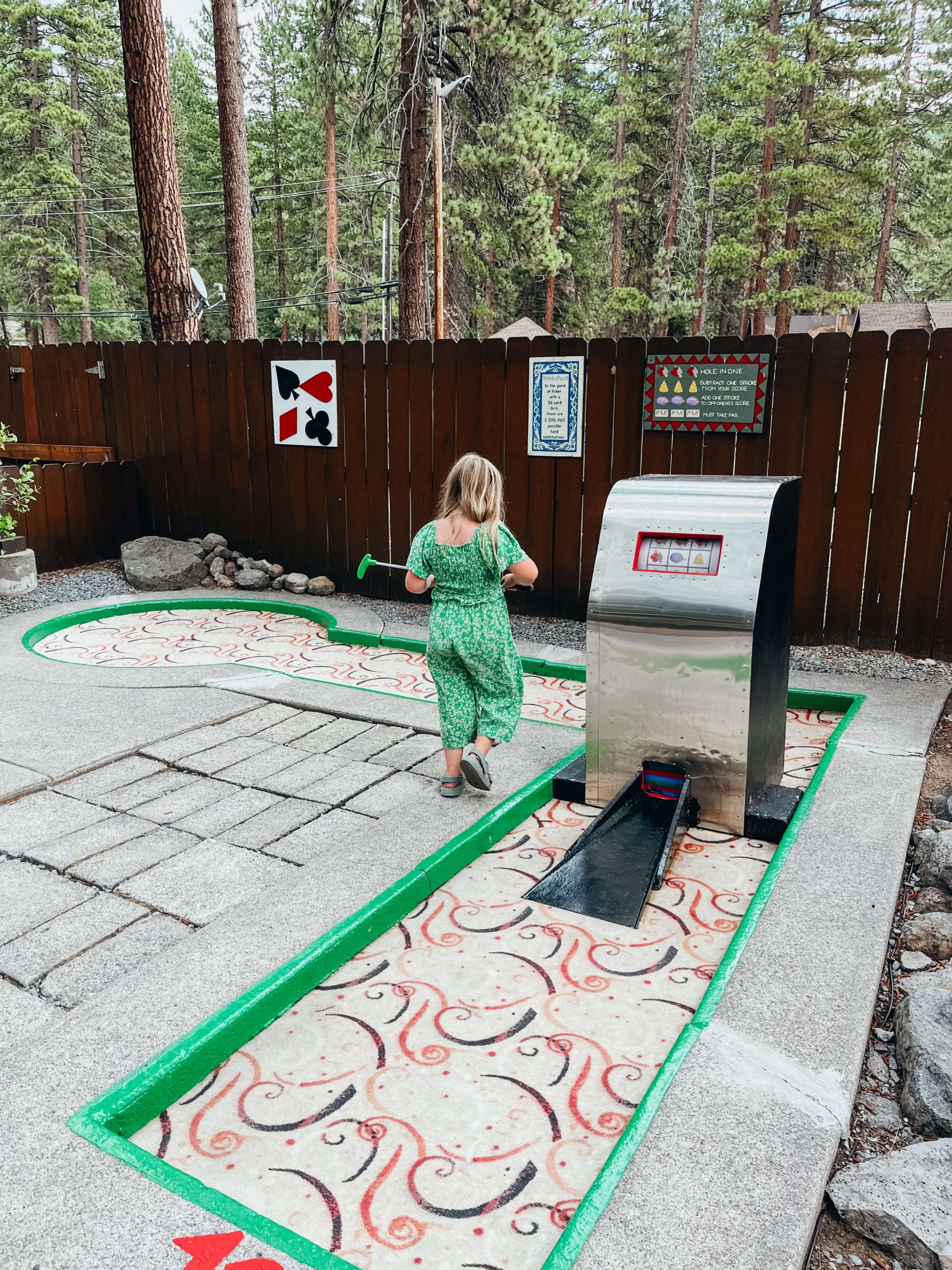 Young girl walks past slot machine on a hole at a miniature golf course at Lake Tahoe
