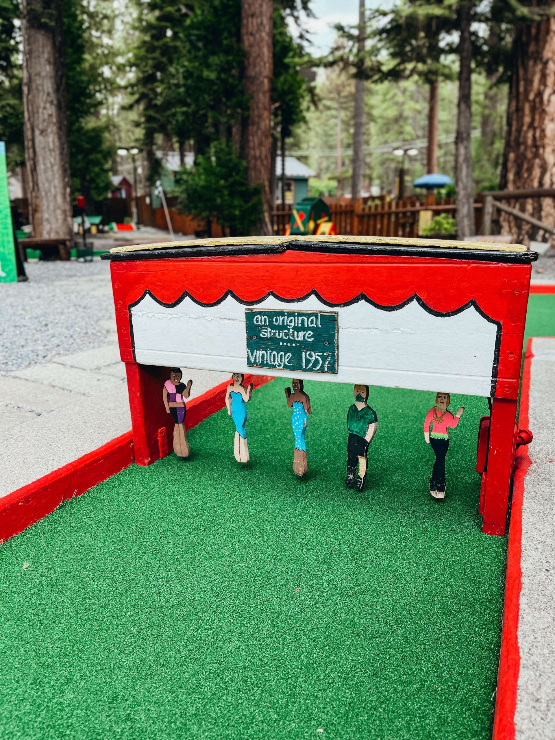 Close up of wooden structure with hand-painted wooden people on mini golf course at Lake Tahoe