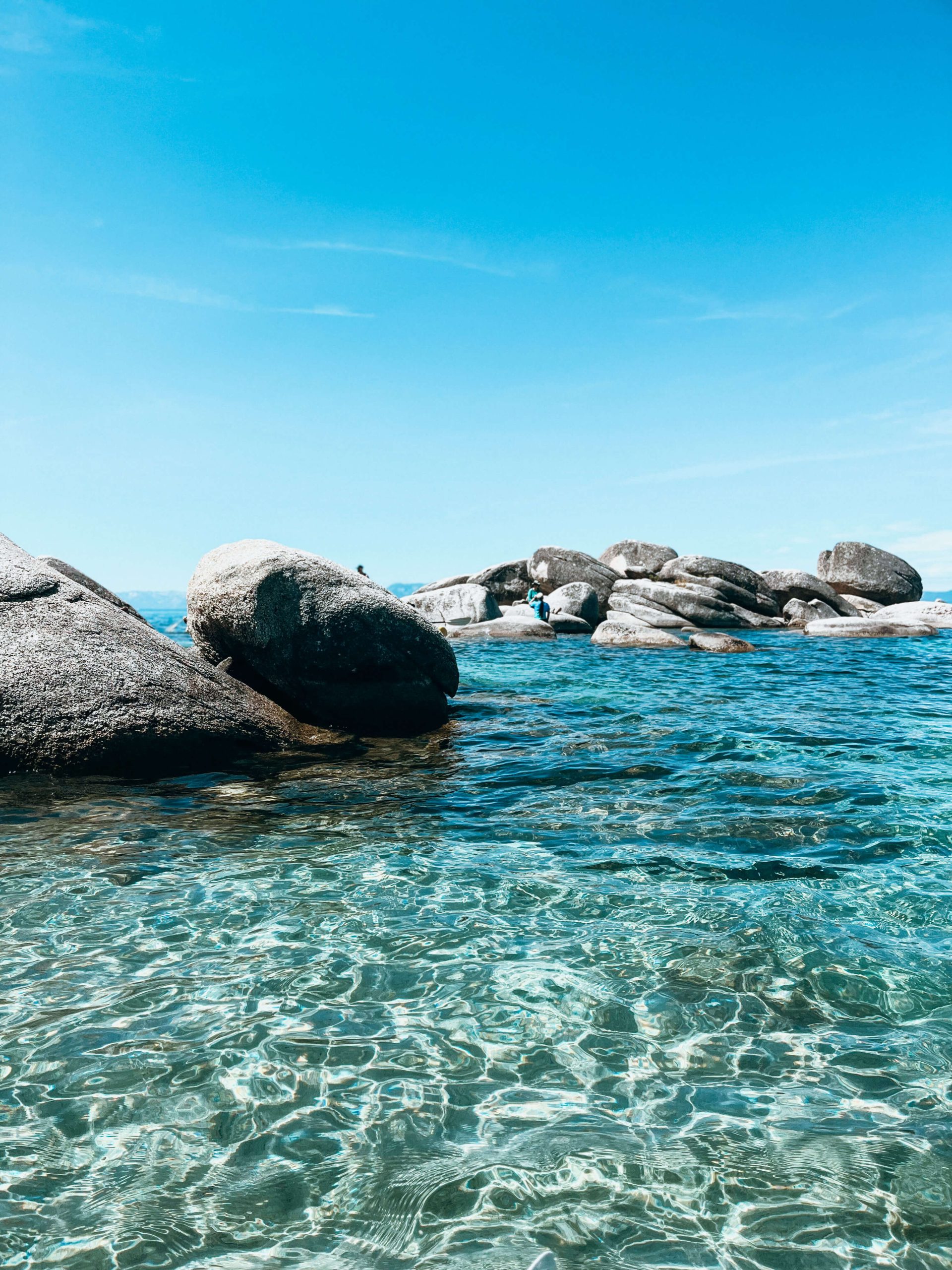 Crystal clear blue water with large granite boulders in Lake Tahoe