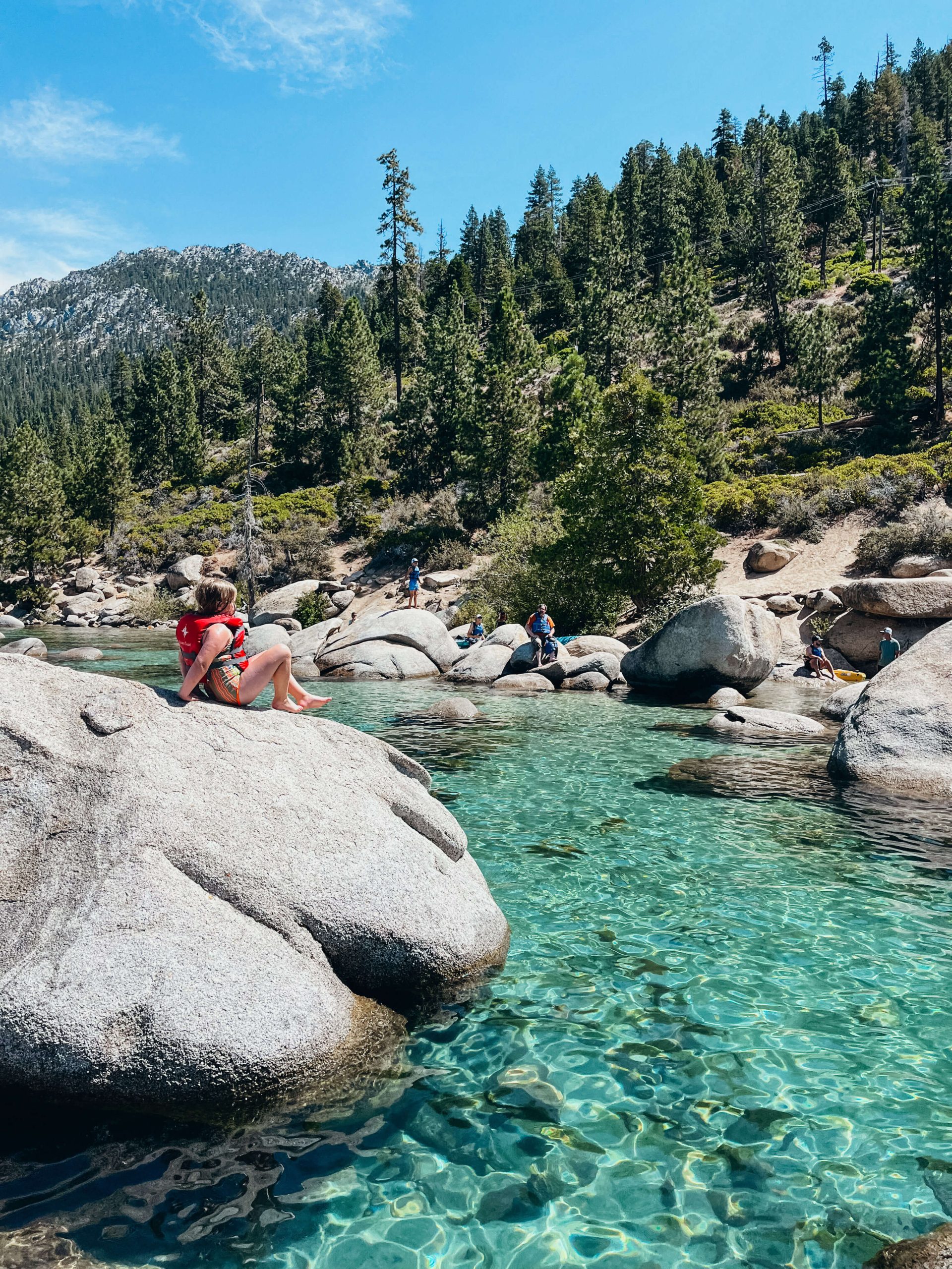 Large granite boulder in clear green and blue water at Lake Tahoe Sand Harbor State Park