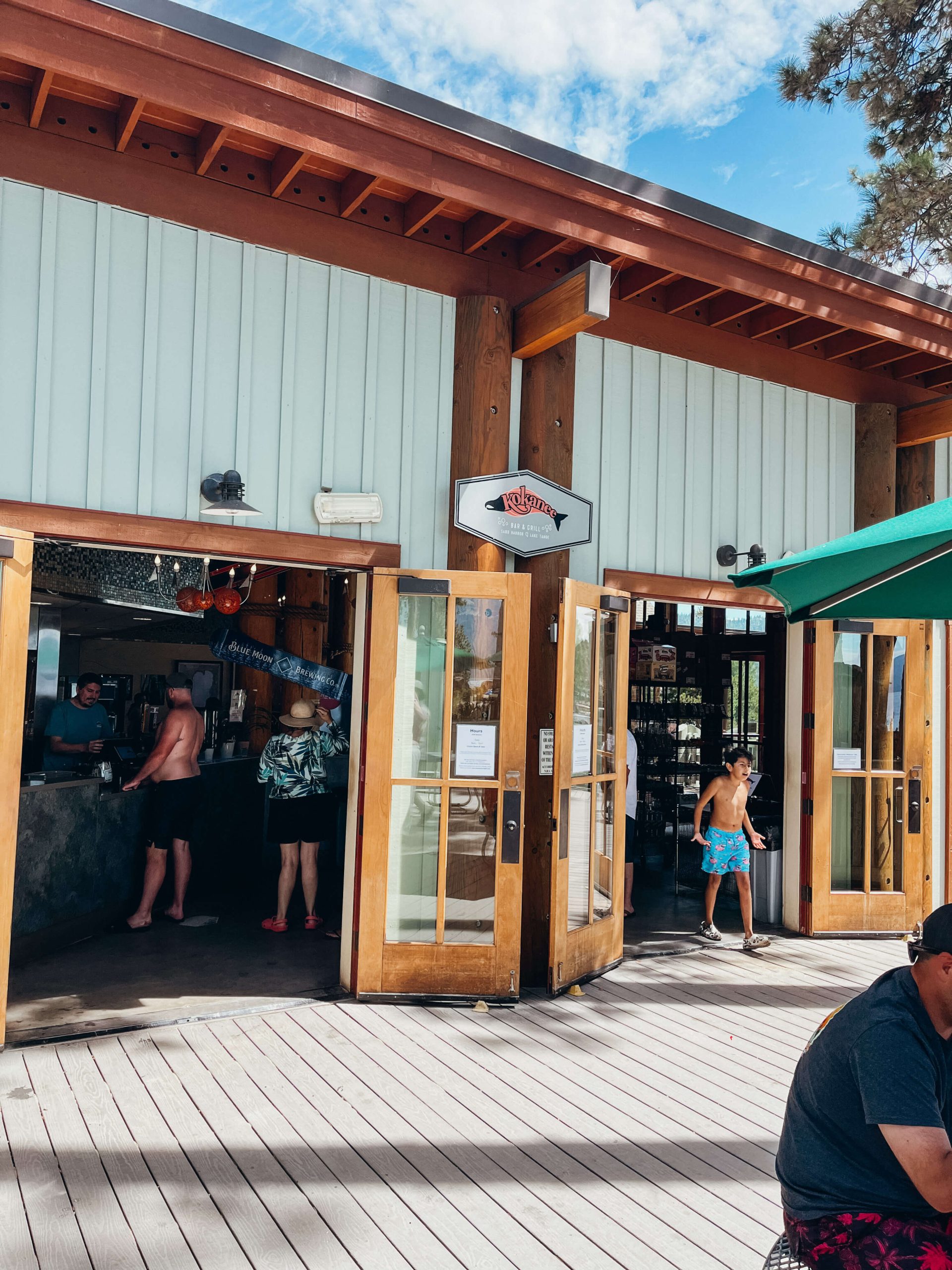 Green and brown building with large doors opening up to a patio at Sand Harbor State Park (Kokanee Bar & Grill)