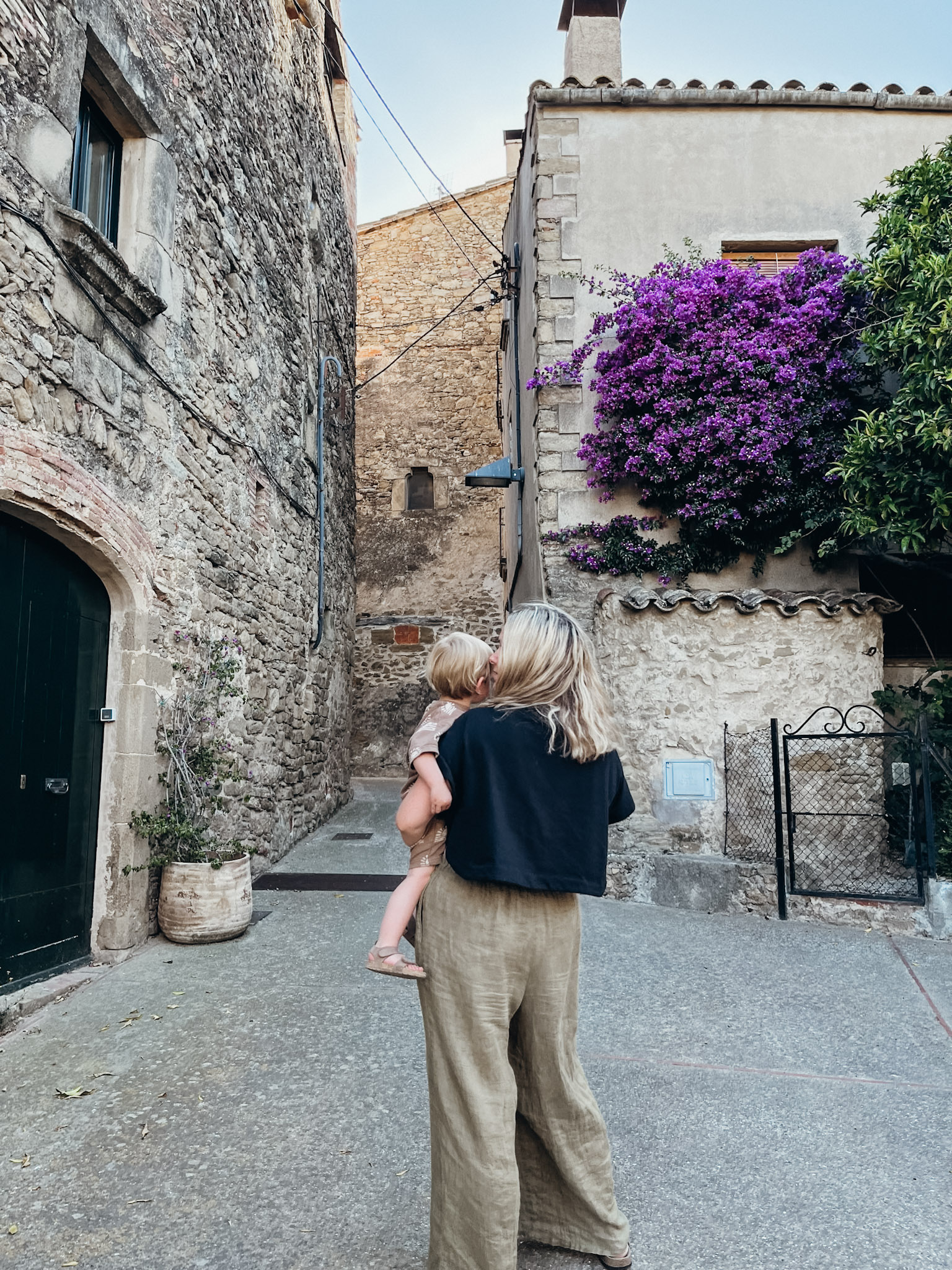 Woman stands with child in medieval village of Madremanya in Spain