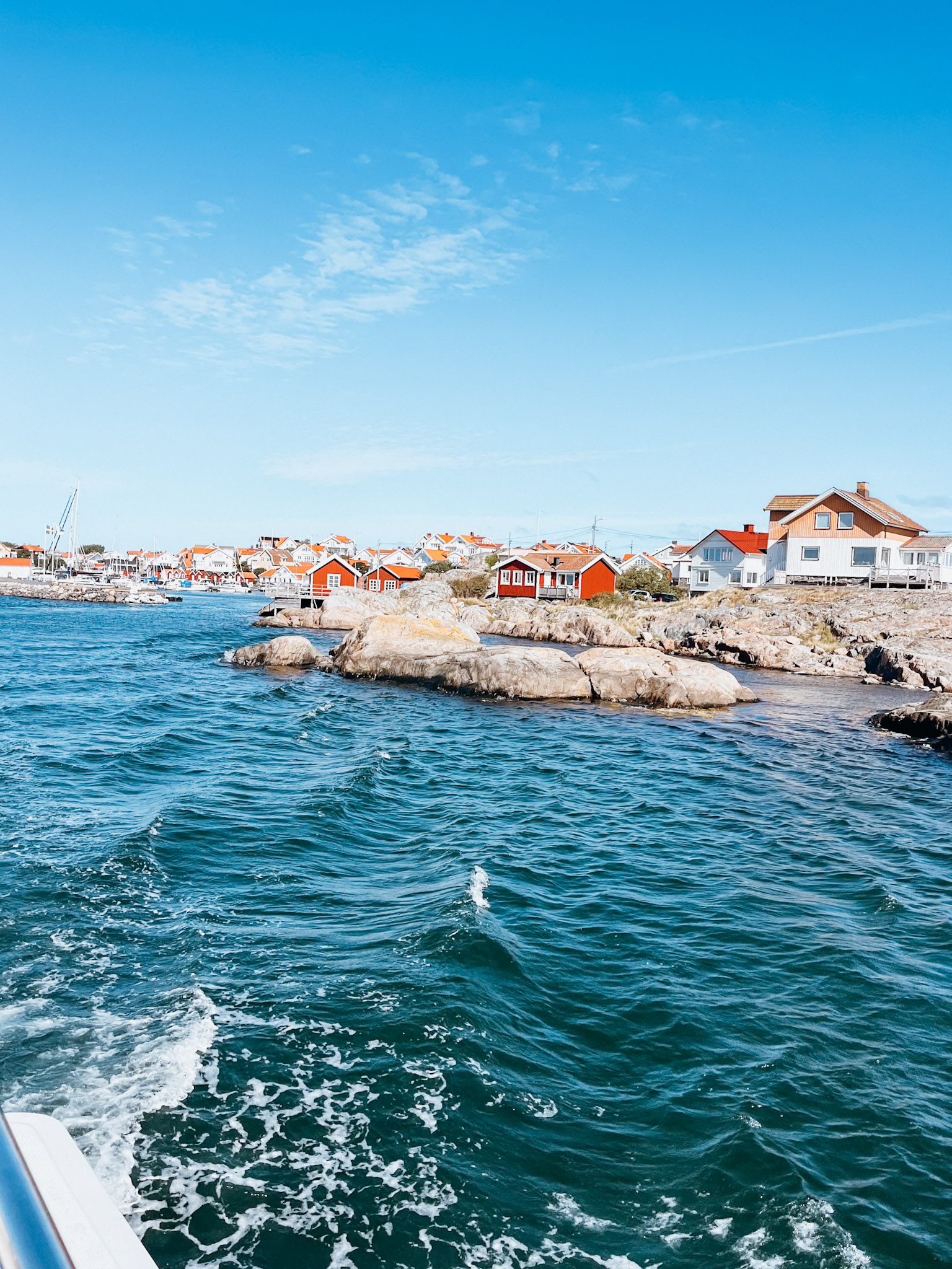 White and red homes along the rocky shoreline of Fotö Sweden near Hono Sweden